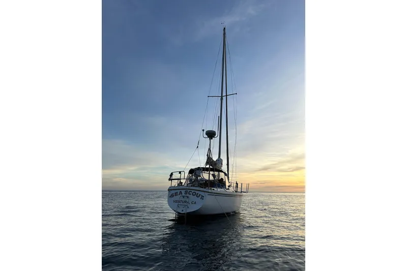 1987 Catalina 34 sailboat on calm ocean at sunset, Ventura, CA.