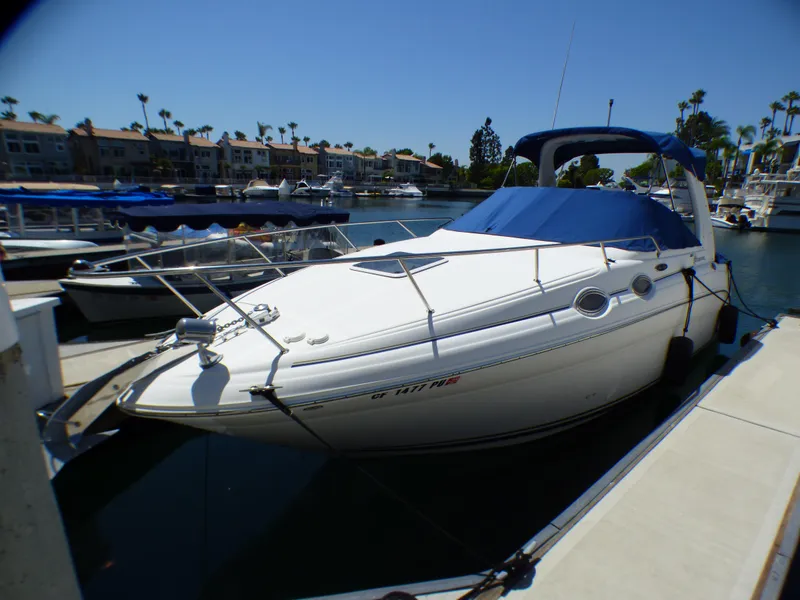 2003 Sea Ray 260 Sundancer docked in a marina under clear blue skies.