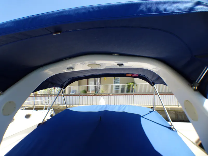 2003 Sea Ray 260 Sundancer boat with blue canopy and sleek design.