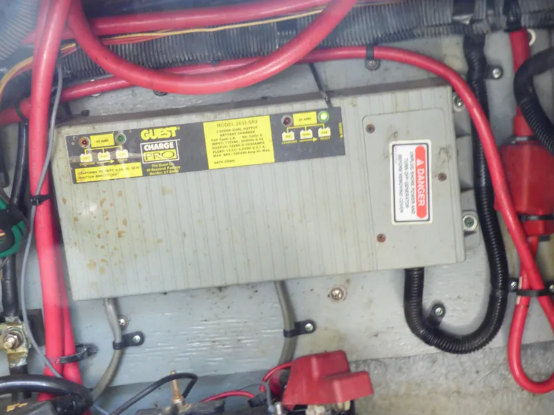 Battery charger in a 2003 Sea Ray 260 Sundancer boat with red cables.