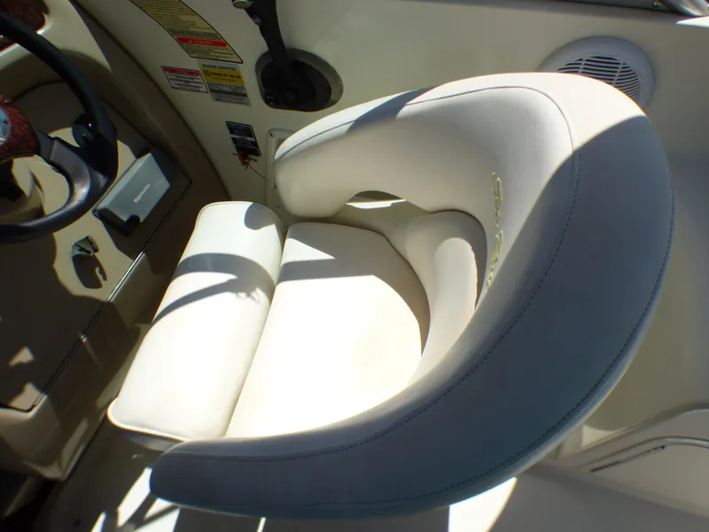 Captain's seat in 2003 Sea Ray 260 Sundancer boat cockpit, featuring beige upholstery.