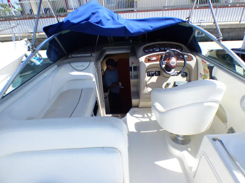 2003 Sea Ray 260 Sundancer boat interior with helm, seating, and cabin entrance.