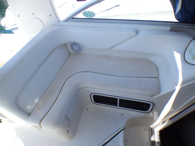 2003 Sea Ray 260 Sundancer interior seating area with white upholstery and speaker.