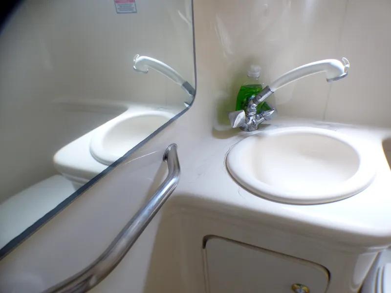 2003 Sea Ray 260 Sundancer bathroom sink with mirror and faucet.