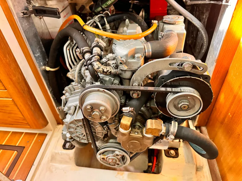 Engine compartment of a 2004 Catalina 350 sailboat, showcasing mechanical components and belts.