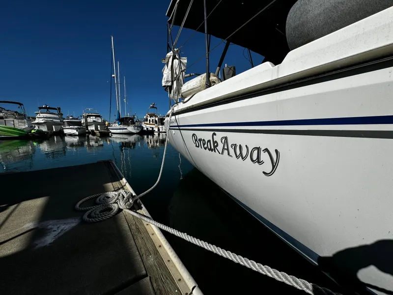 Catalina 350 sailboat named "BreakAway" docked at a marina, clear blue sky.