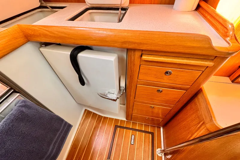 2004 Catalina 350 yacht interior with wooden cabinetry and compact kitchen area.