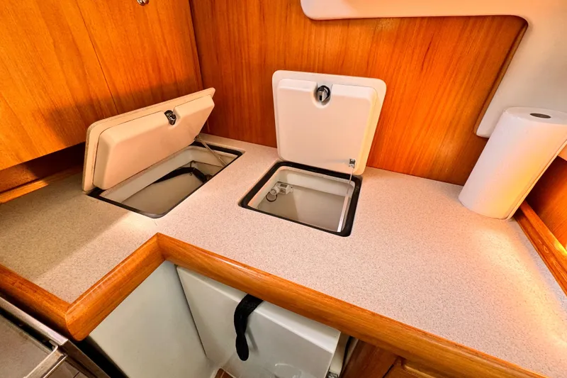 2004 Catalina 350 yacht kitchen with wooden cabinetry and built-in storage compartments.
