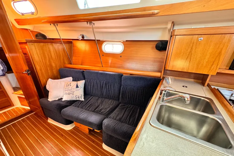 Interior of 2004 Catalina 350 sailboat with cozy seating and compact kitchen area.
