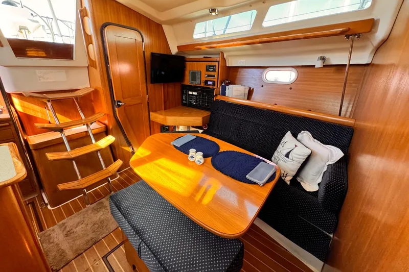 Interior of 2004 Catalina 350 sailboat with wooden furnishings and cozy dining area.