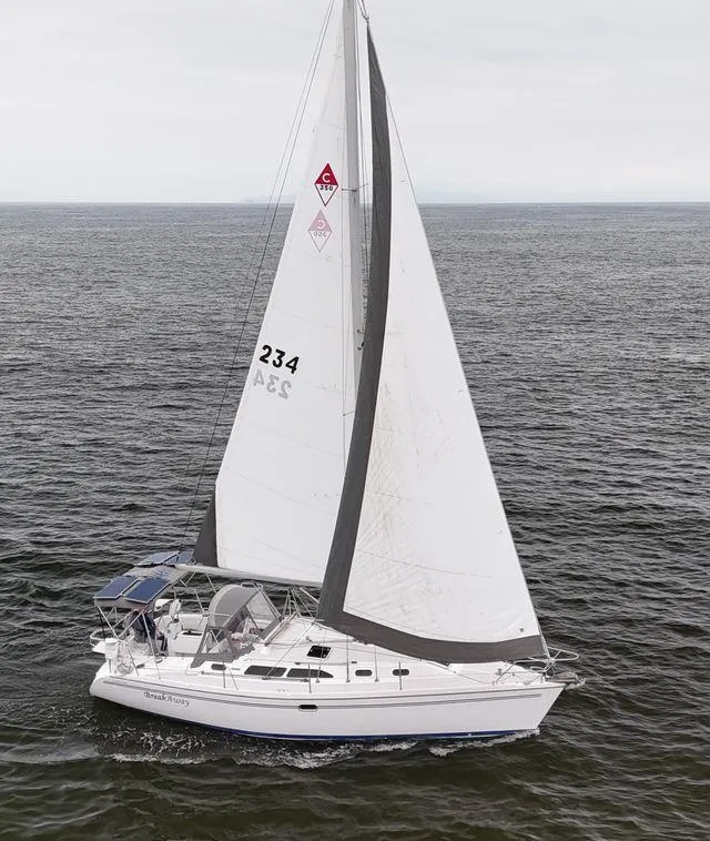 2004 Catalina 350 sailboat navigating calm waters under cloudy skies.