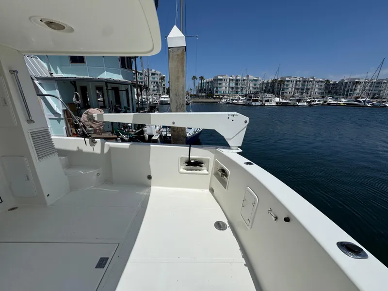1999 McKinna 47 Sedan yacht docked at marina with clear blue sky.