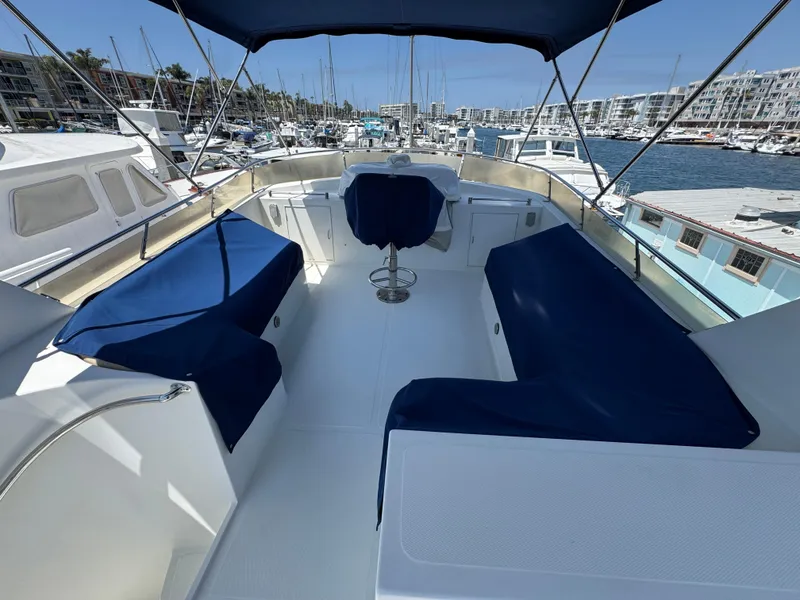 1999 McKinna 47 Sedan yacht with blue seating, docked in a marina.