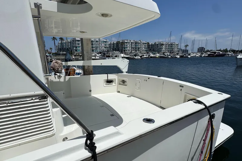 1999 McKinna 47 Sedan yacht docked in marina, featuring spacious deck and modern design.
