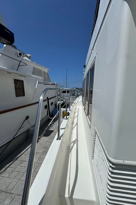Side view of a 1999 McKinna 47 Sedan yacht docked at a marina.