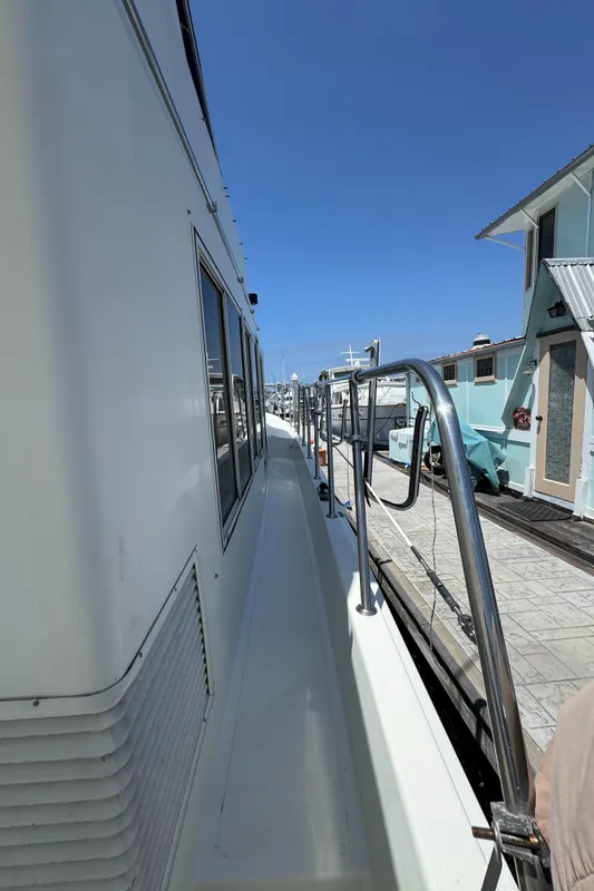 1999 McKinna 47 Sedan yacht docked, side view with clear blue sky.