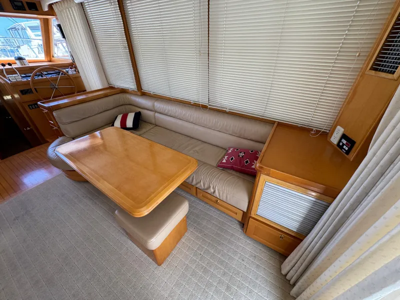 Interior of 1999 McKinna 47 Sedan with beige seating and wooden table.
