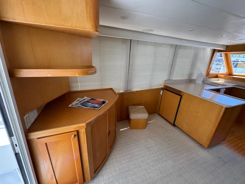 Interior of 1999 McKinna 47 Sedan yacht with wooden cabinetry and blinds.