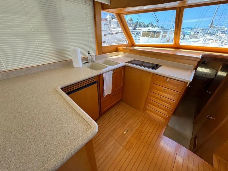 Interior of 1999 McKinna 47 Sedan yacht with modern kitchen and large windows.