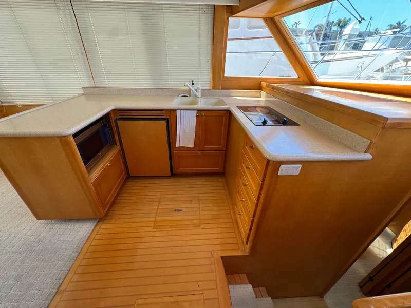 1999 McKinna 47 Sedan yacht kitchen with wooden cabinetry and modern appliances.