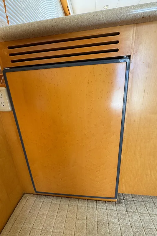 Wood-paneled refrigerator in 1999 McKinna 47 Sedan yacht interior.