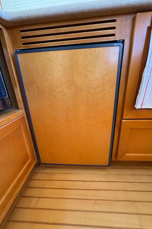 Wood-paneled refrigerator in 1999 McKinna 47 Sedan yacht kitchen.