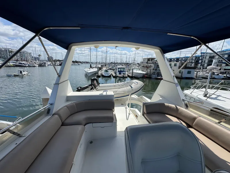 1999 McKinna 47 Sedan yacht interior with marina view, featuring comfortable seating and canopy.