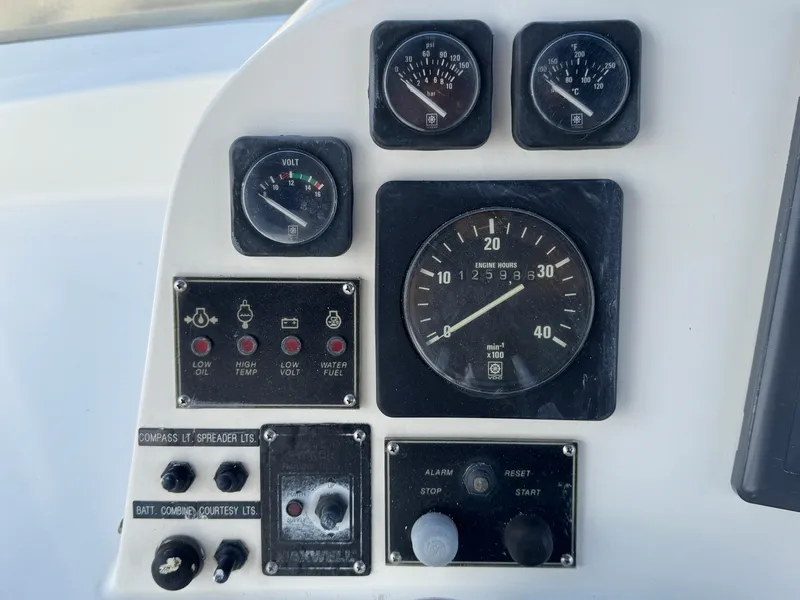 Control panel of a 1999 McKinna 47 Sedan boat with gauges and switches.