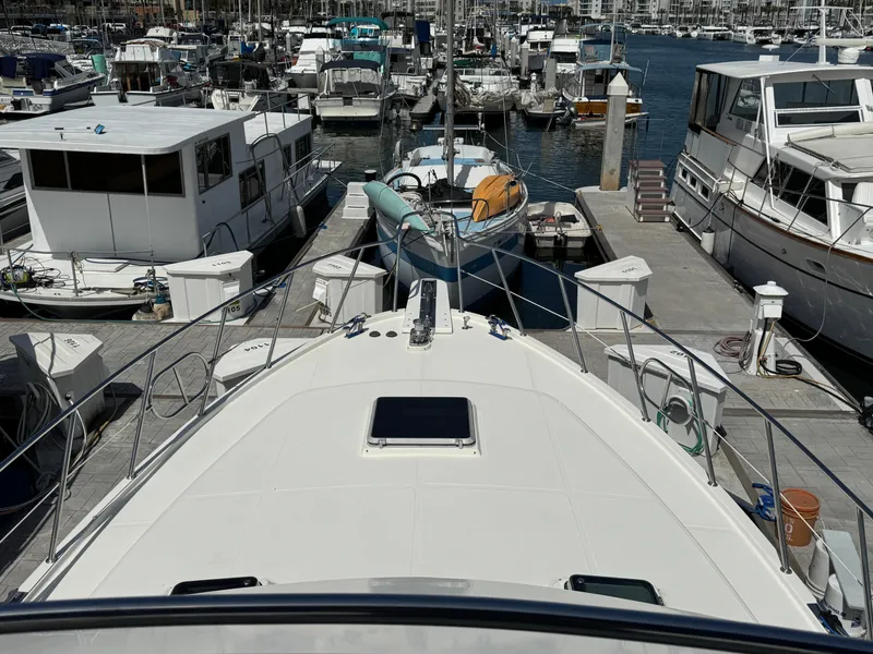 1999 McKinna 47 Sedan yacht docked at a marina with surrounding boats.
