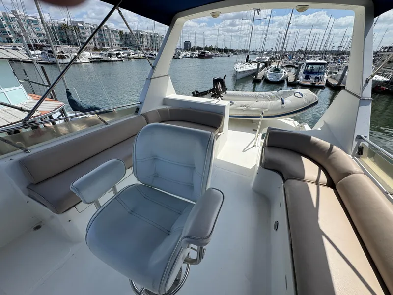 1999 McKinna 47 Sedan yacht interior with seating, docked at marina.