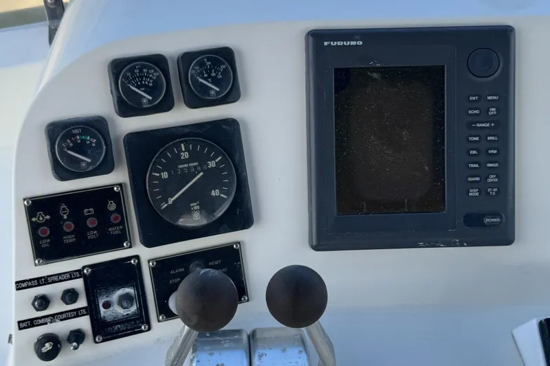 Control panel of a 1999 McKinna 47 Sedan yacht with gauges and navigation display.