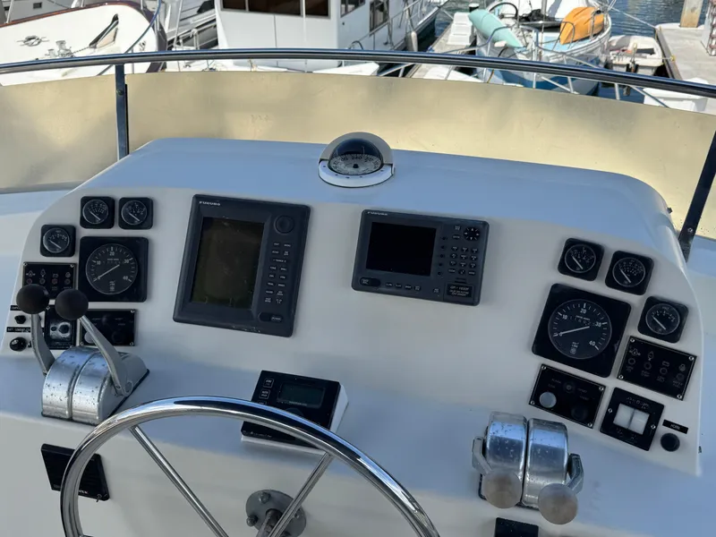 Helm of 1999 McKinna 47 Sedan yacht with navigation instruments and steering wheel.