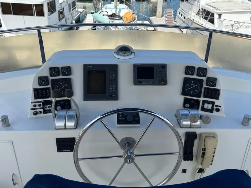 1999 McKinna 47 Sedan yacht helm with navigation instruments and steering wheel.