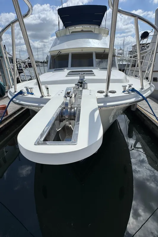 1999 McKinna 47 Sedan yacht docked, showcasing sleek design and spacious deck.