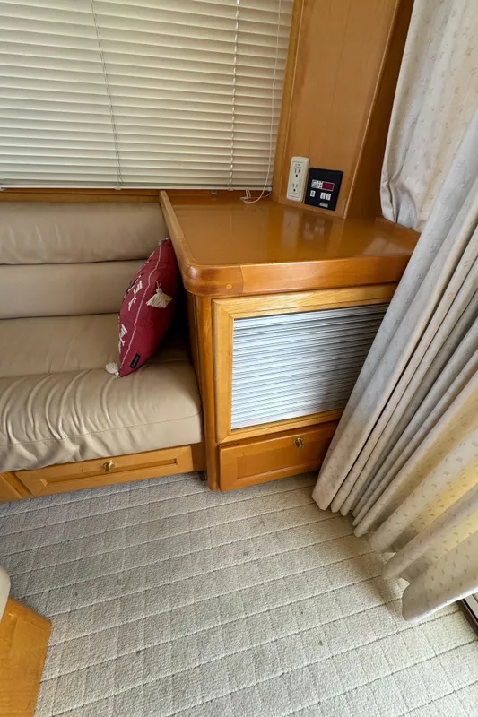 Interior of 1999 McKinna 47 Sedan with beige seating and wooden cabinetry.