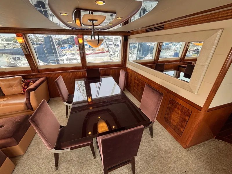 Luxurious dining area on a 2010 Norseman 80 yacht with elegant furnishings and marina view.