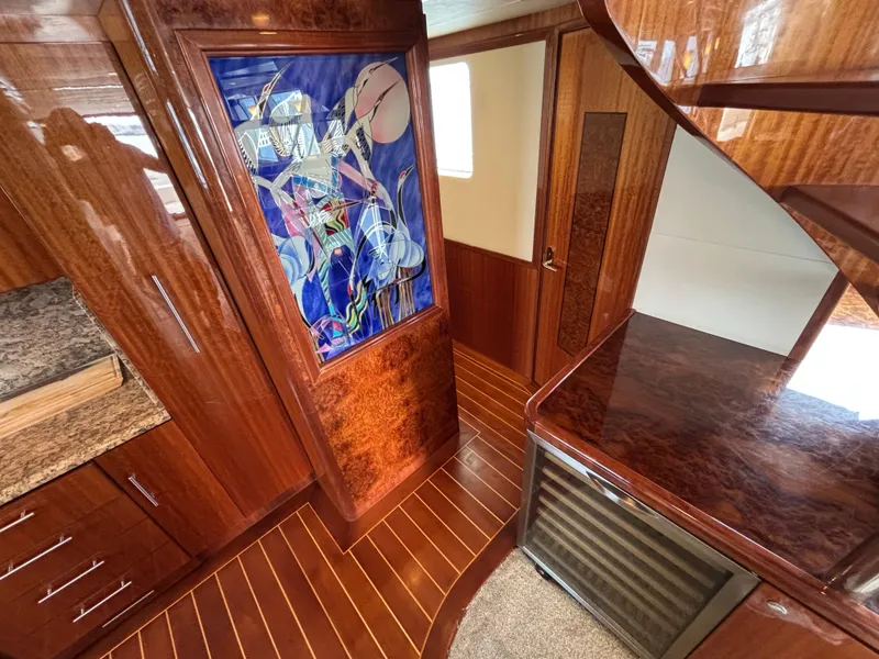 Luxurious Norseman 80 yacht interior with wood paneling and vibrant abstract artwork, 2010 model.