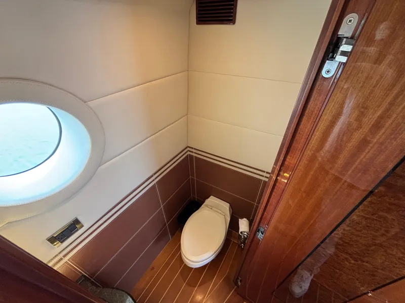 Luxurious Norseman 80 yacht bathroom with porthole, wooden accents, and modern fixtures, 2010 model.