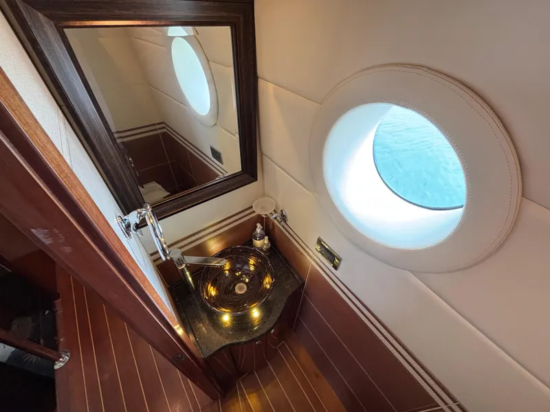 Luxurious Norseman 80 yacht bathroom with porthole, elegant sink, and wooden accents, 2010 model.