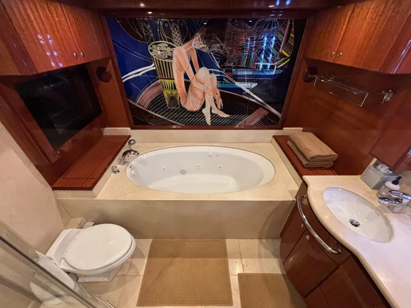 Luxurious Norseman 80 yacht bathroom with jacuzzi, elegant wood finishes, and artistic wall design.