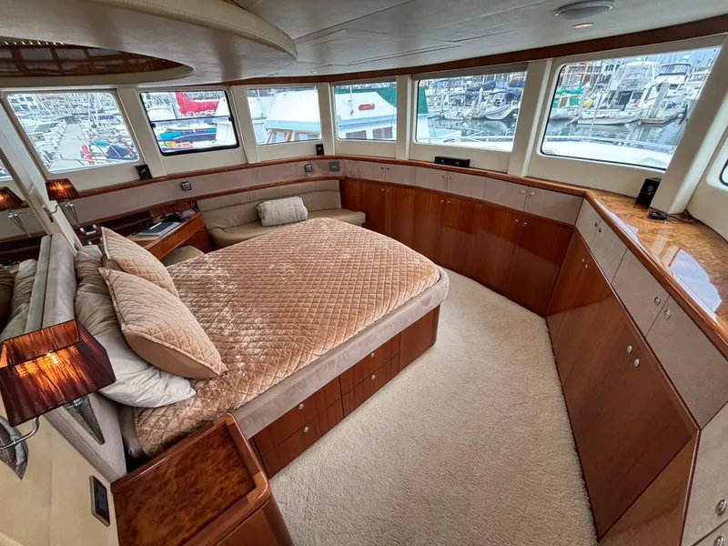 Luxurious Norseman 80 yacht bedroom interior with panoramic windows, plush bedding, and elegant wood finishes.