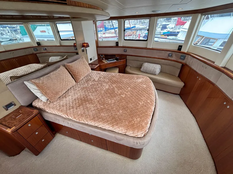 Luxurious bedroom interior of 2010 Norseman 80 yacht with plush bedding and panoramic windows.