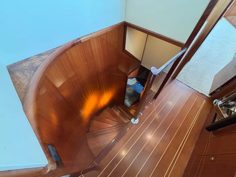 Curved wooden staircase on Norseman 80 yacht, 2010 model, with elegant design and warm lighting.