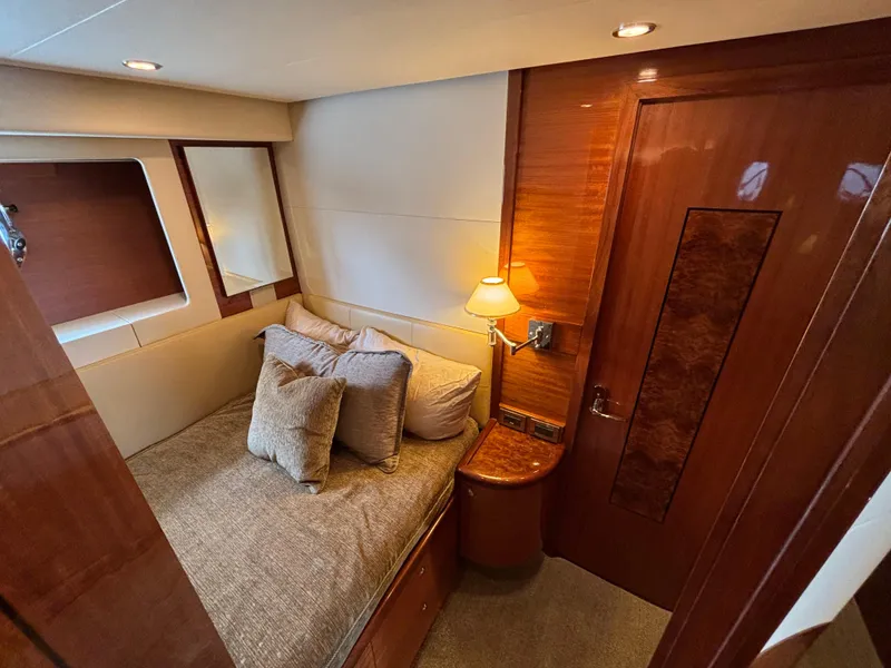 Luxurious cabin interior of 2010 Norseman 80 yacht with cozy bed and elegant wood finishes.