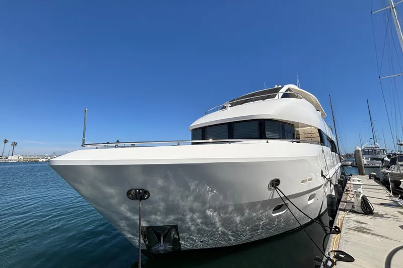 Luxurious 2010 Norseman 80 yacht docked at marina under clear blue sky.