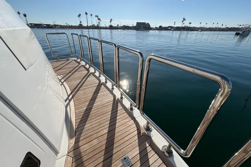 Deck of 2010 Norseman 80 yacht with stainless steel railings and scenic harbor view.