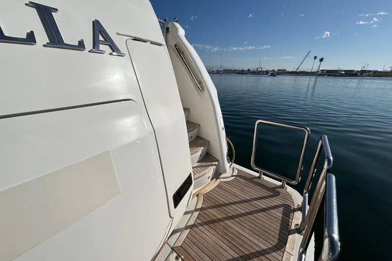 Stern view of 2010 Norseman 80 yacht with wooden deck and marina backdrop.