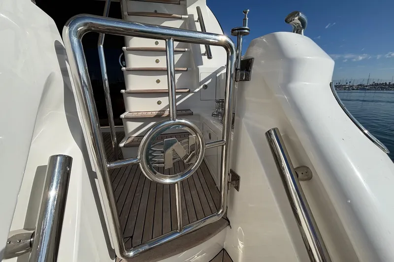 Stainless steel gate on 2010 Norseman 80 yacht with wooden deck and marina view.