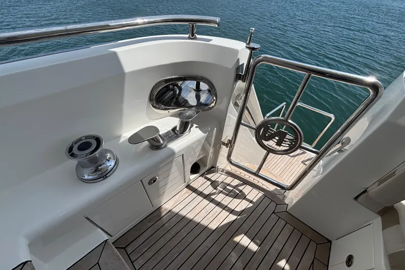 Norseman 80 yacht deck, 2010 model, featuring stainless steel gate and winch by the water.