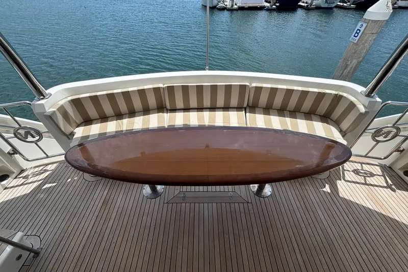 Luxury yacht deck with striped seating and polished wooden table, Norseman 80, 2010 model.